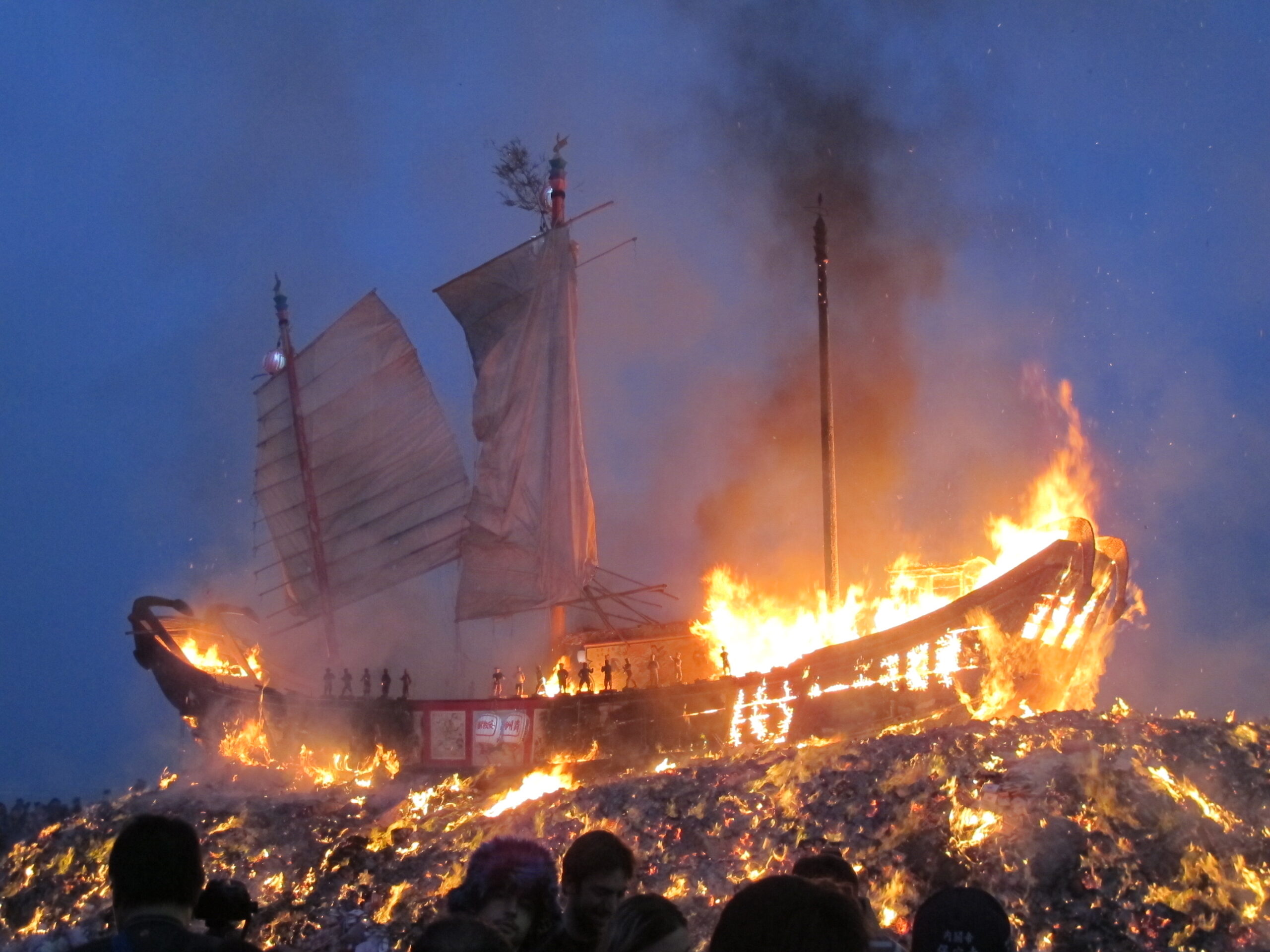 As dawn breaks, the boat is still aflame
