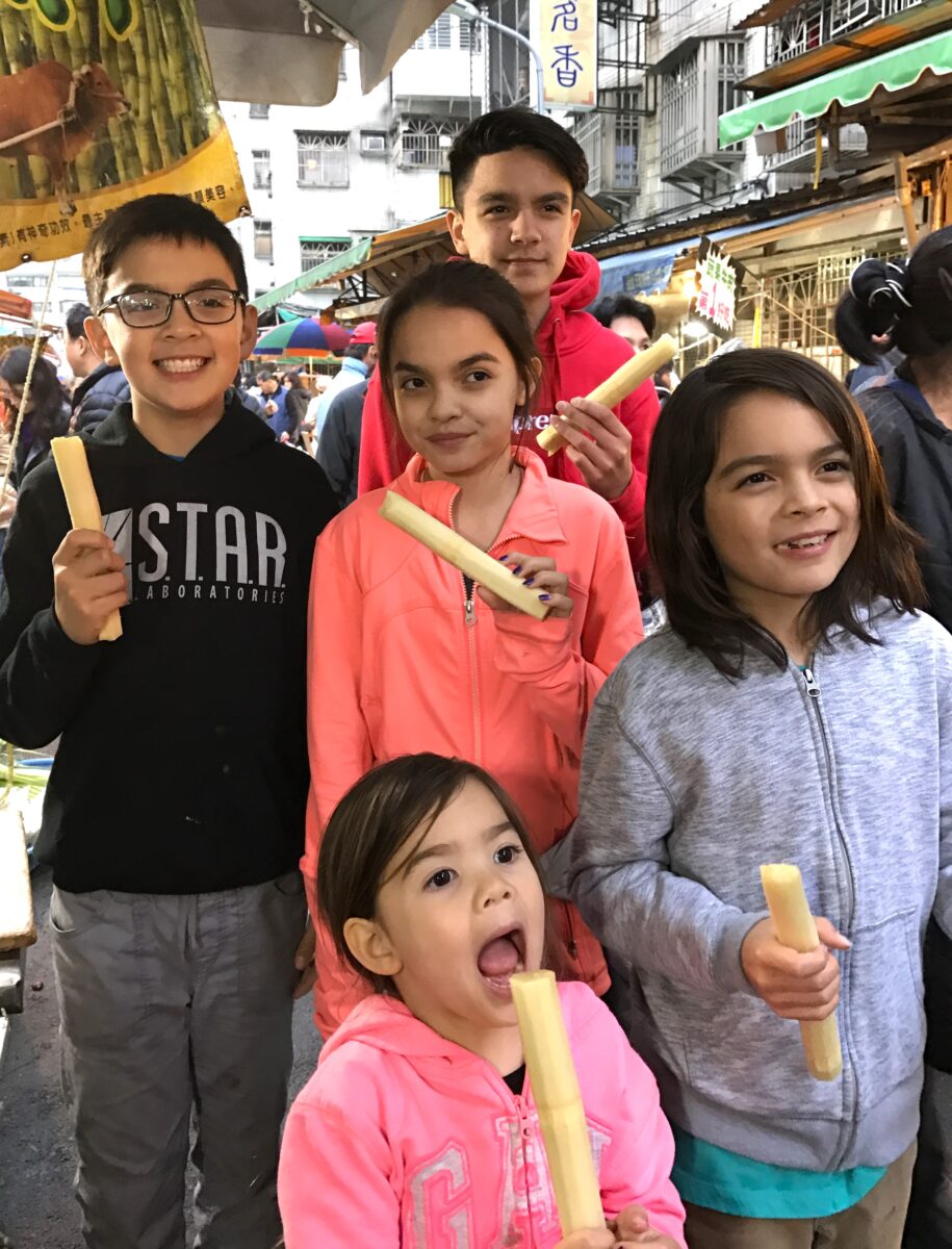 Young tourists enjoy chewing sugarcane in Taiwan night market